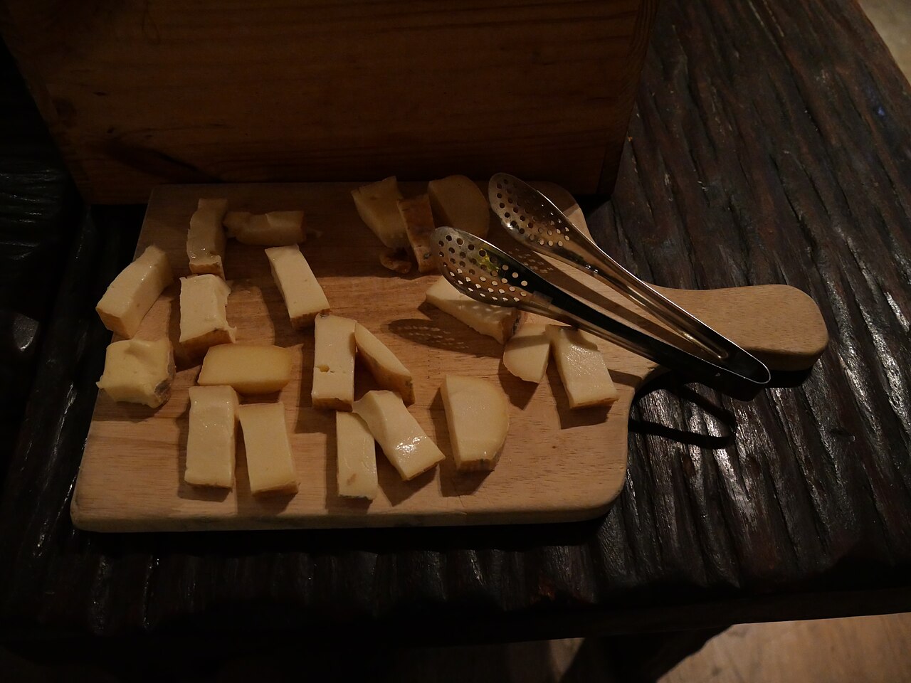 A cheese board with pieces of cheese