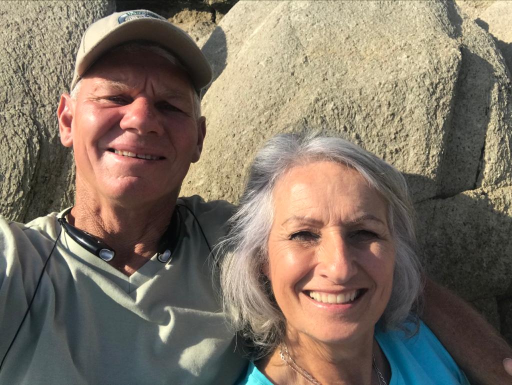 Dad and Monica smiling outdoors near large rocks