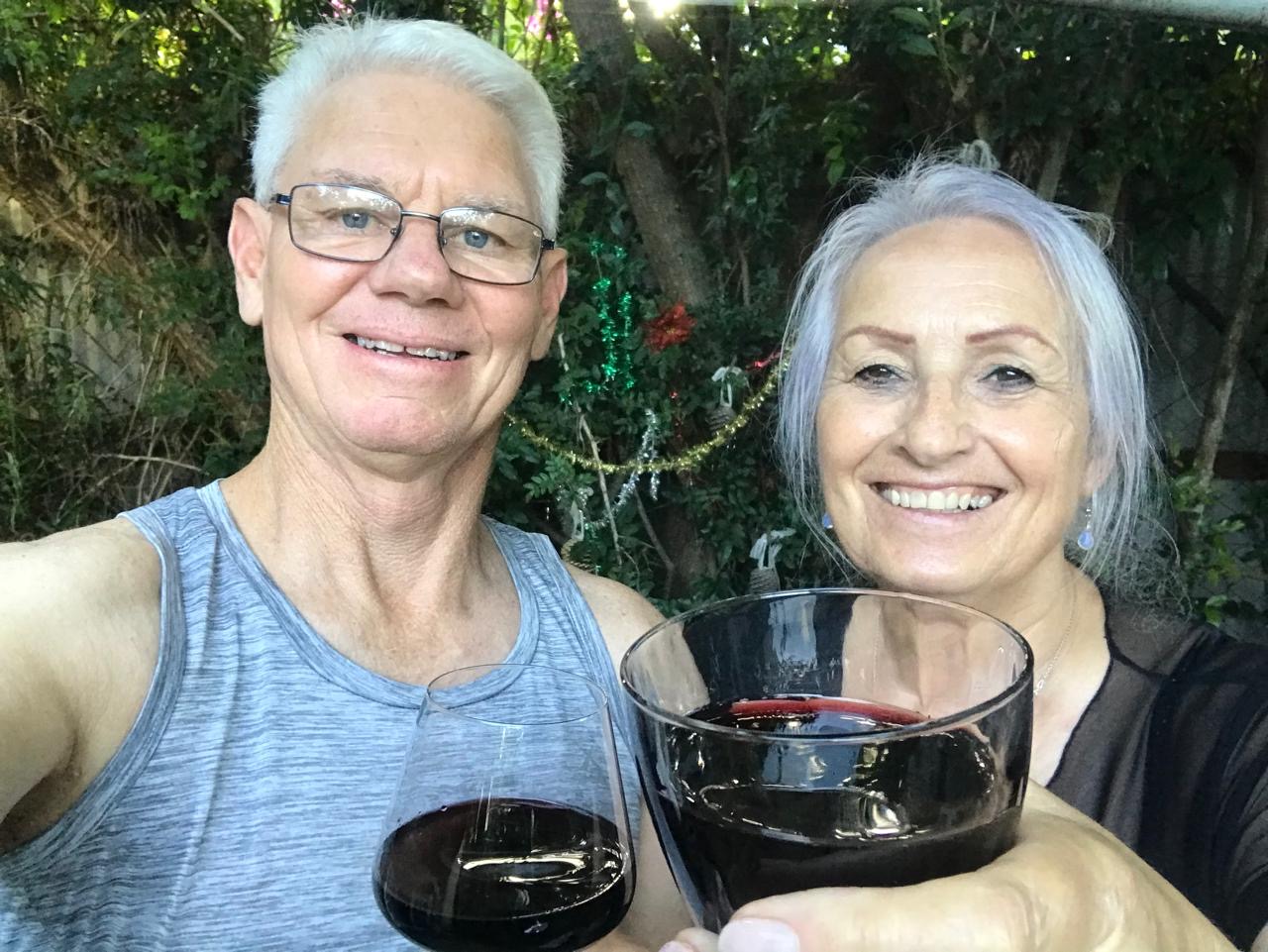 Dad and Monica raising glasses of red wine
