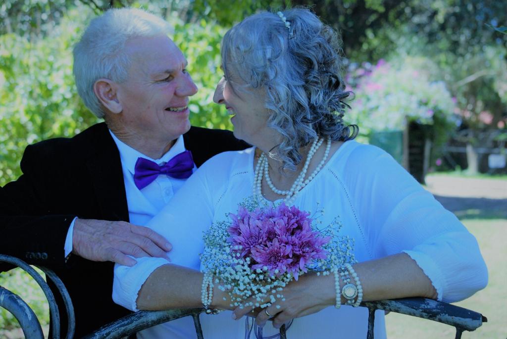 Dad and Monica dressed up outdoors with flowers