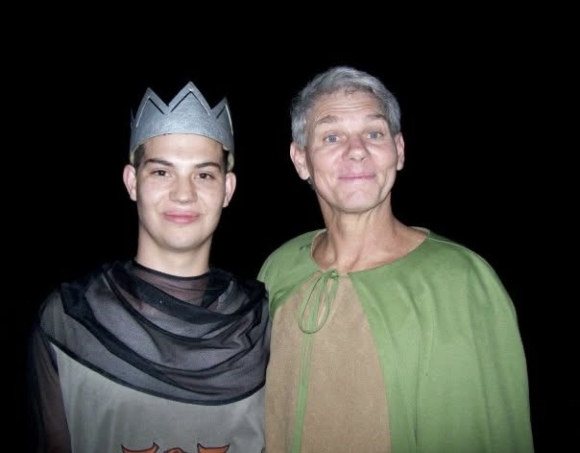 Dad in costume standing with a younger man wearing a crown